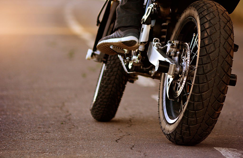 Man riding motorcyle, close up on tires.