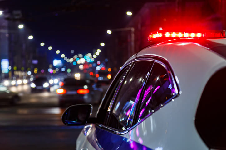 Cop car flashing its lights at night