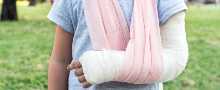 Girl with arm in a cast with sling over shoulder