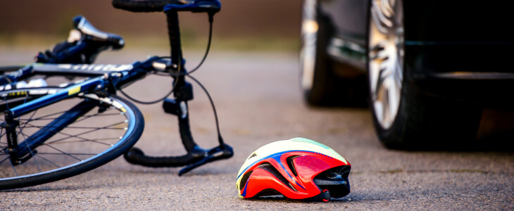 Bike and helmet laying on the ground after car accident